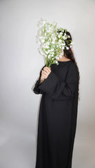 Eine naturfarbene Abaya in Leinenoptik, knöchellang, Frontansicht – schlichtes Modest-Fashion-Basic.