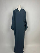 Dunkelpetrolfarbene Wickel-Abaya im Modest-Stil zeigt Ballonärmel und Seitenschleife in Vorderansicht.