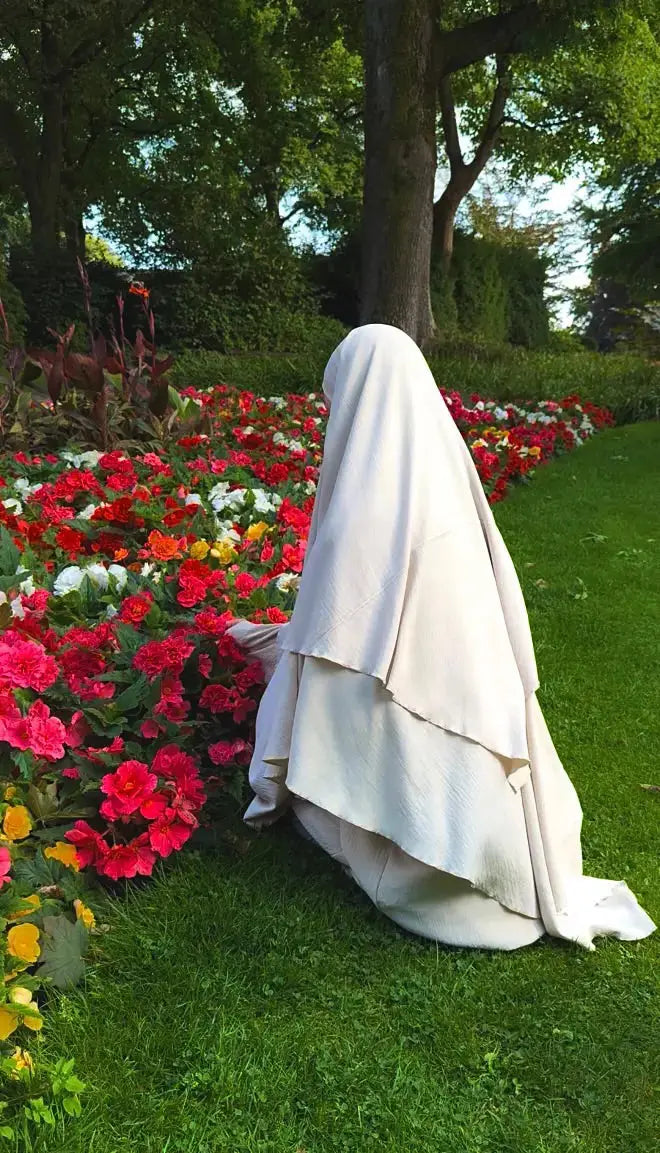 Ein cremefarbener, zweilagiger Khimar aus Jazz fällt fließend bis bodenlang, Rückenansicht
