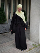 zweiteiler in schwarz, lockeres oberteil mit weiten ärmeln und maxirock, frontansicht