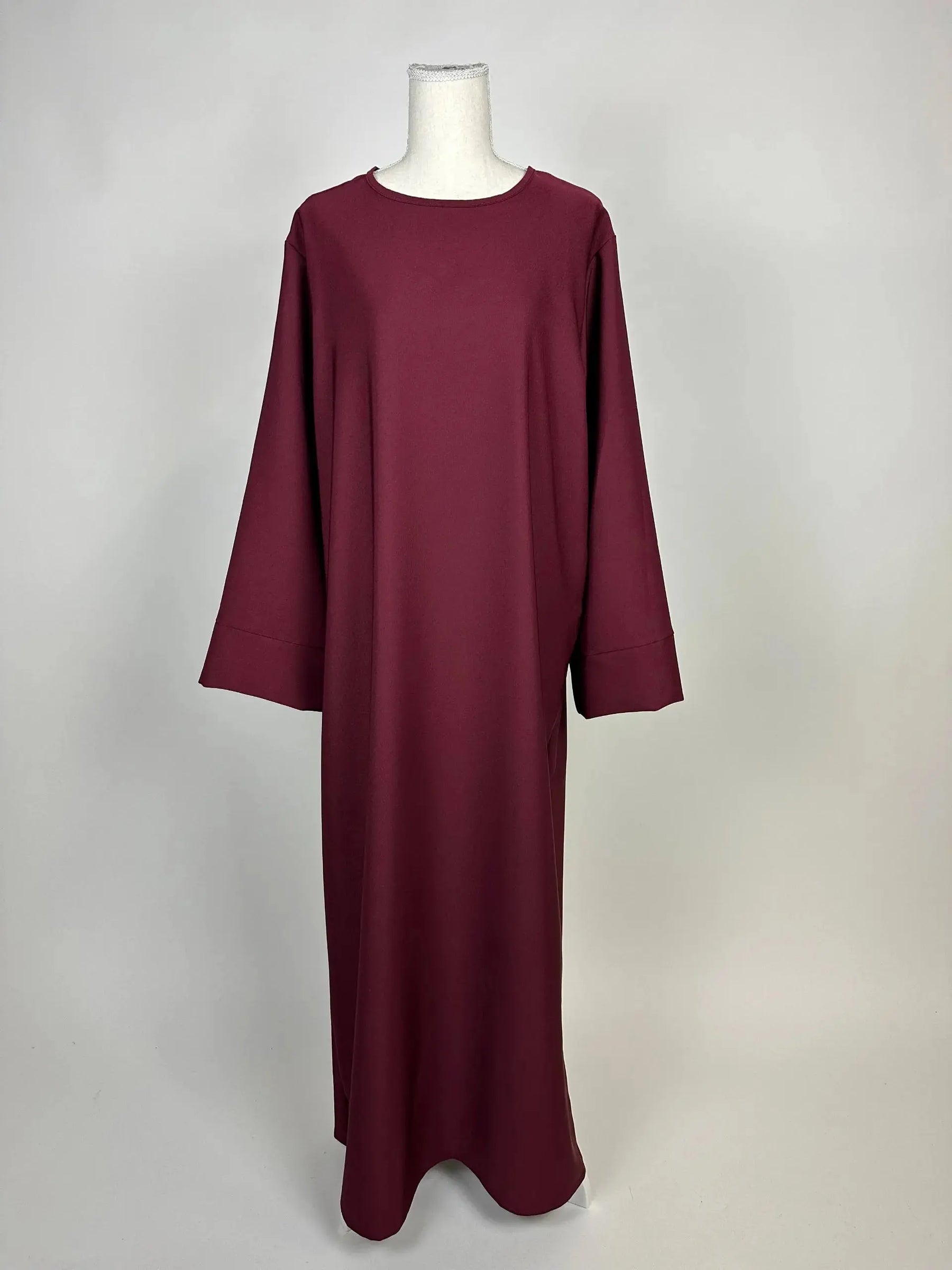 bordeauxrote lange abaya aus polyester mit weiten ärmeln und rundhalsausschnitt, vorderansicht auf schaufensterpuppe