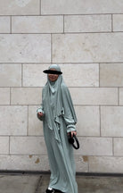 salbeigrünes abaya‑khimar set aus fließendem stoff, abaya mit ballonärmeln, khimar mit doppellagigem saum, frontansicht