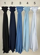 Mehrfarbige Hijabs aus Crinkle-Stoff mit gewelltem Saum, hängend auf Stange, Vorderansicht