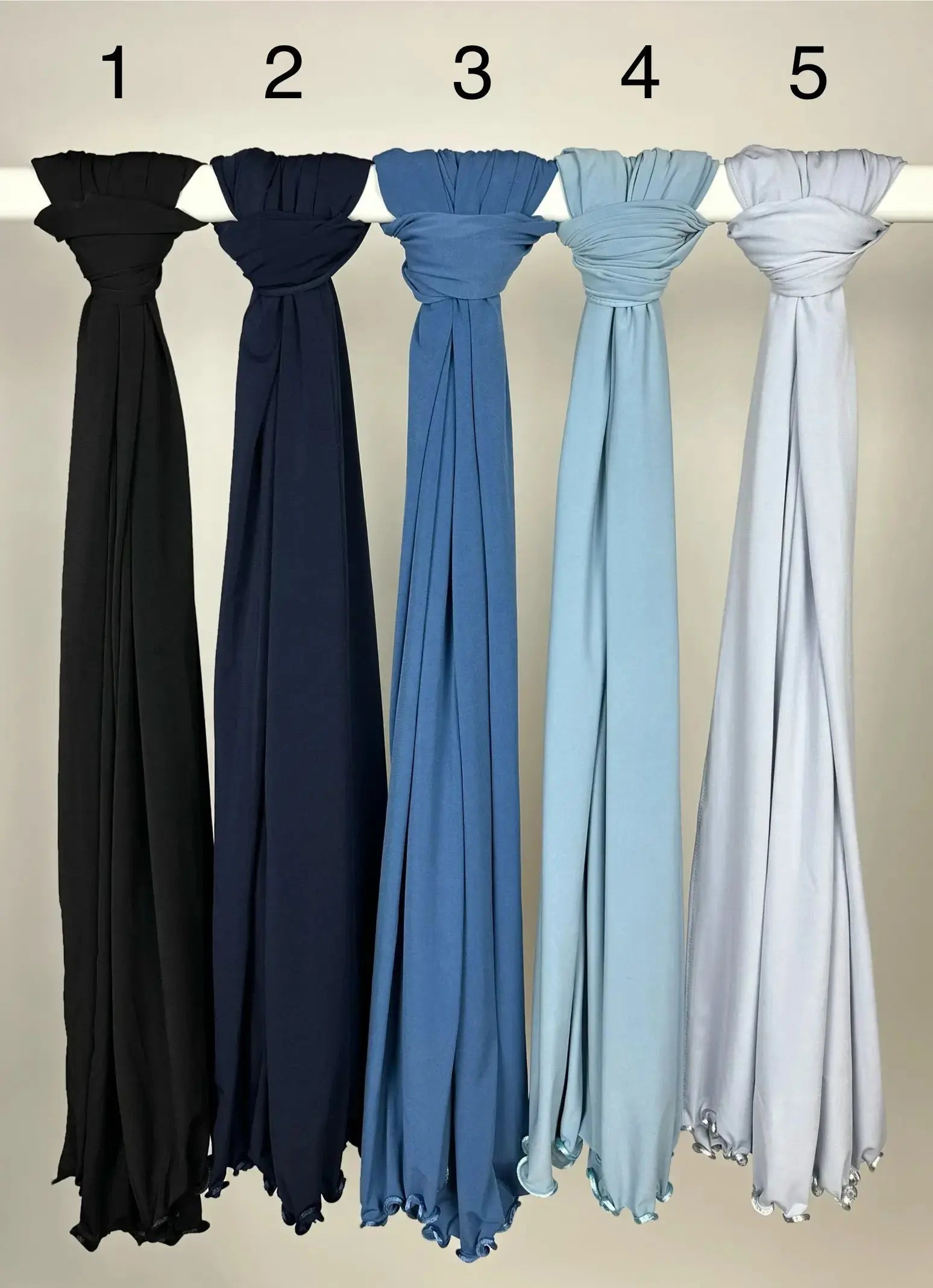 Mehrfarbige Hijabs aus Crinkle-Stoff mit gewelltem Saum, hängend auf Stange, Vorderansicht