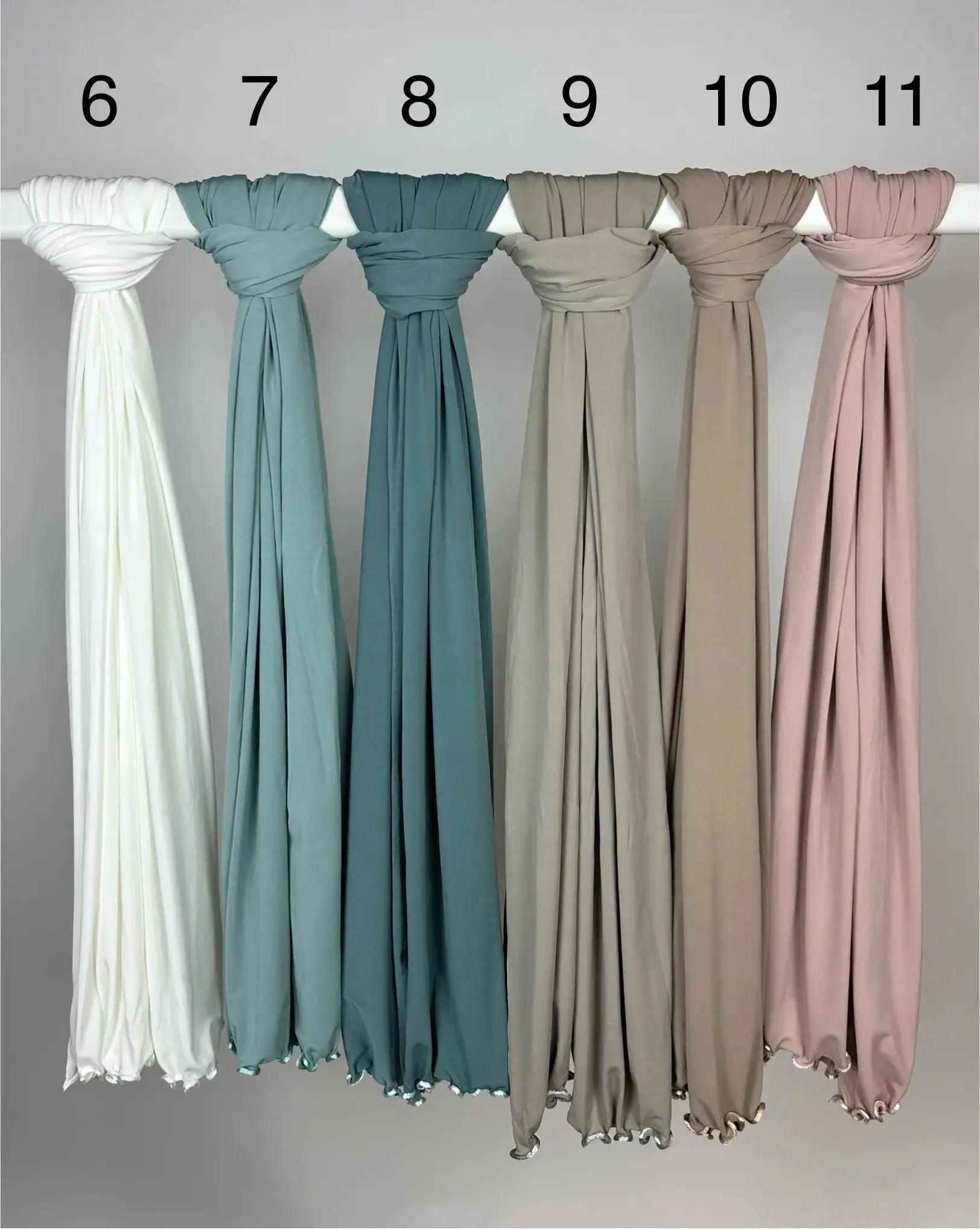 Mehrfarbige Crinkle-Hijabs aus leichtem Stoff mit gewelltem Saum, nummeriert und hängend an Stange, Frontansicht