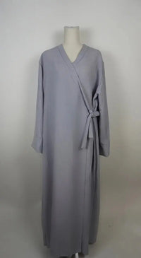 Graue Wickelabaya in Leinenoptik mit seitlicher Schleife wird in der Vorderansicht gezeigt, Modest Hijab Fashion