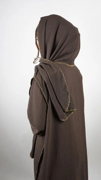 Braune Einteiler-Abaya aus Crinkle-Stoff mit integriertem Hijab und goldener Kantenverzierung, Rückansicht.