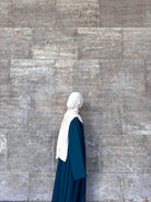 Petrolfabene Basic-Abaya aus fließendem Stoff mit weiten Ärmeln und weißtem Hijab, Seitenansicht