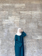 Petrolfabene Basic-Abaya aus fließendem Stoff mit weiten Ärmeln und weißtem Hijab, Frontansicht