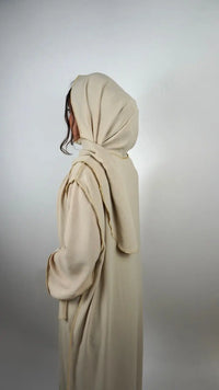 Beige Einteiler-Abaya aus Crêpe mit integriertem Hijab und goldener Kantenpaspel, seitliche Rückansicht
