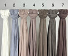 Neutrale Hijabs aus Jersey für Modest Abaya sind geknotet und mit Zahlen auf Stange, Vorderansicht