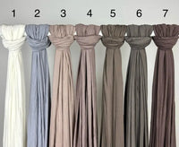 Neutrale Hijabs aus Jersey für Modest Abaya sind geknotet und mit Zahlen auf Stange, Vorderansicht
