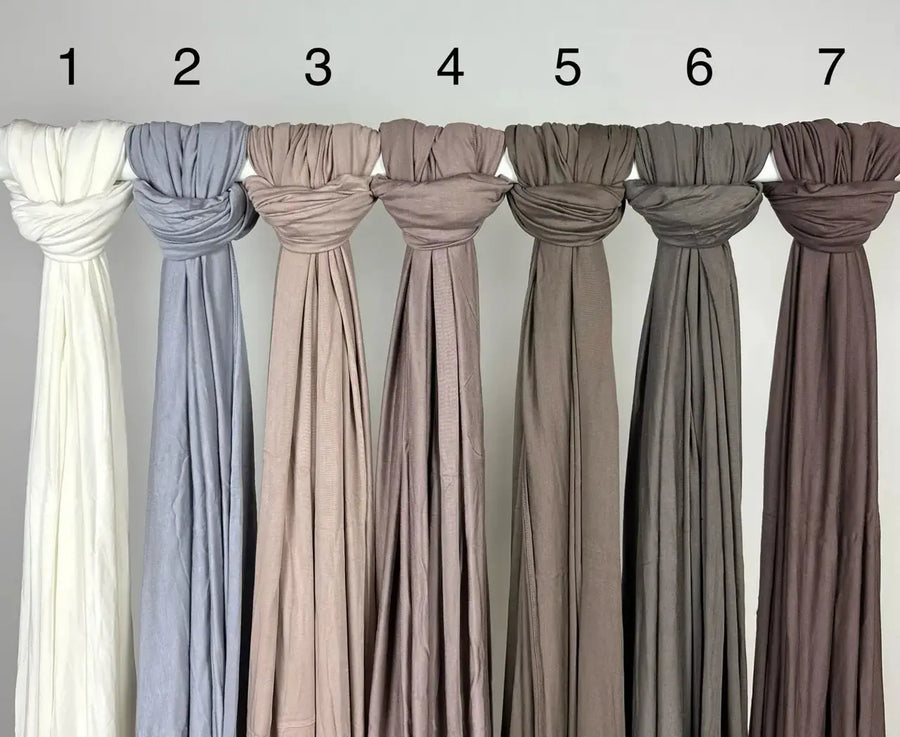 Neutrale Hijabs aus Jersey für Modest Abaya sind geknotet und mit Zahlen auf Stange, Vorderansicht