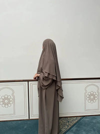 Abaya in taupe aus Jazz-Stoff mit Ballonärmeln, mit zweilagigem Khimar, Seitenansicht.