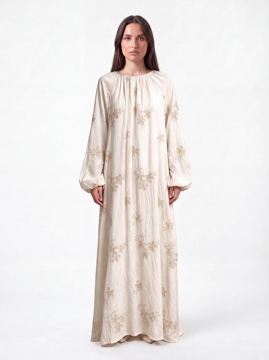 Kleid in champagner mit goldener Blumenstickerei, weiten Ballonärmeln und gerafftem Rundhalsausschnitt, Frontalansicht.