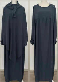 Abaya und Khimar in anthrazit; Khimar lang, gebunden vorn, Abaya mit geraffter Brust und Rüschenärmeln, Frontansicht.