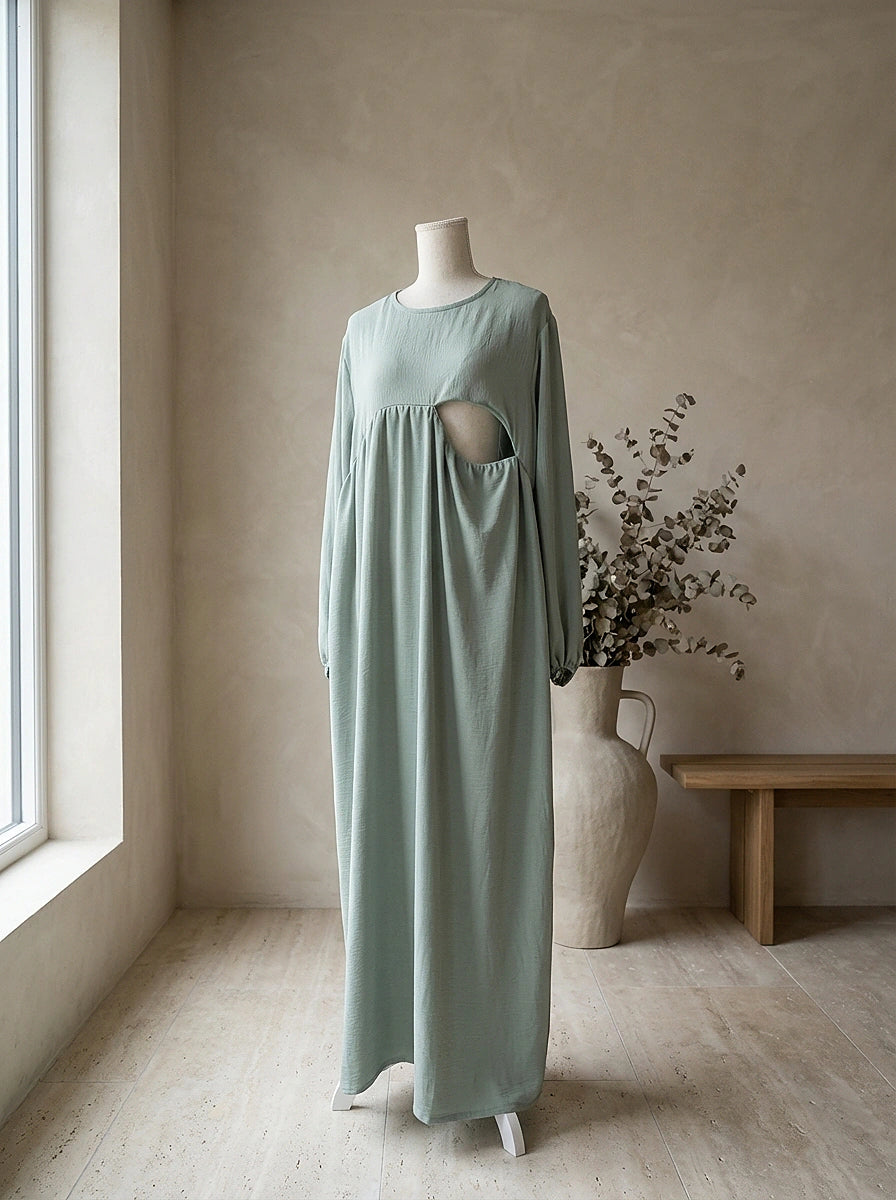 Mintgrüne Still-Abaya aus leichtem Crinkle-Stoff mit seitlicher Stillöffnung unter der Brust, Vorderansicht auf Puppe.