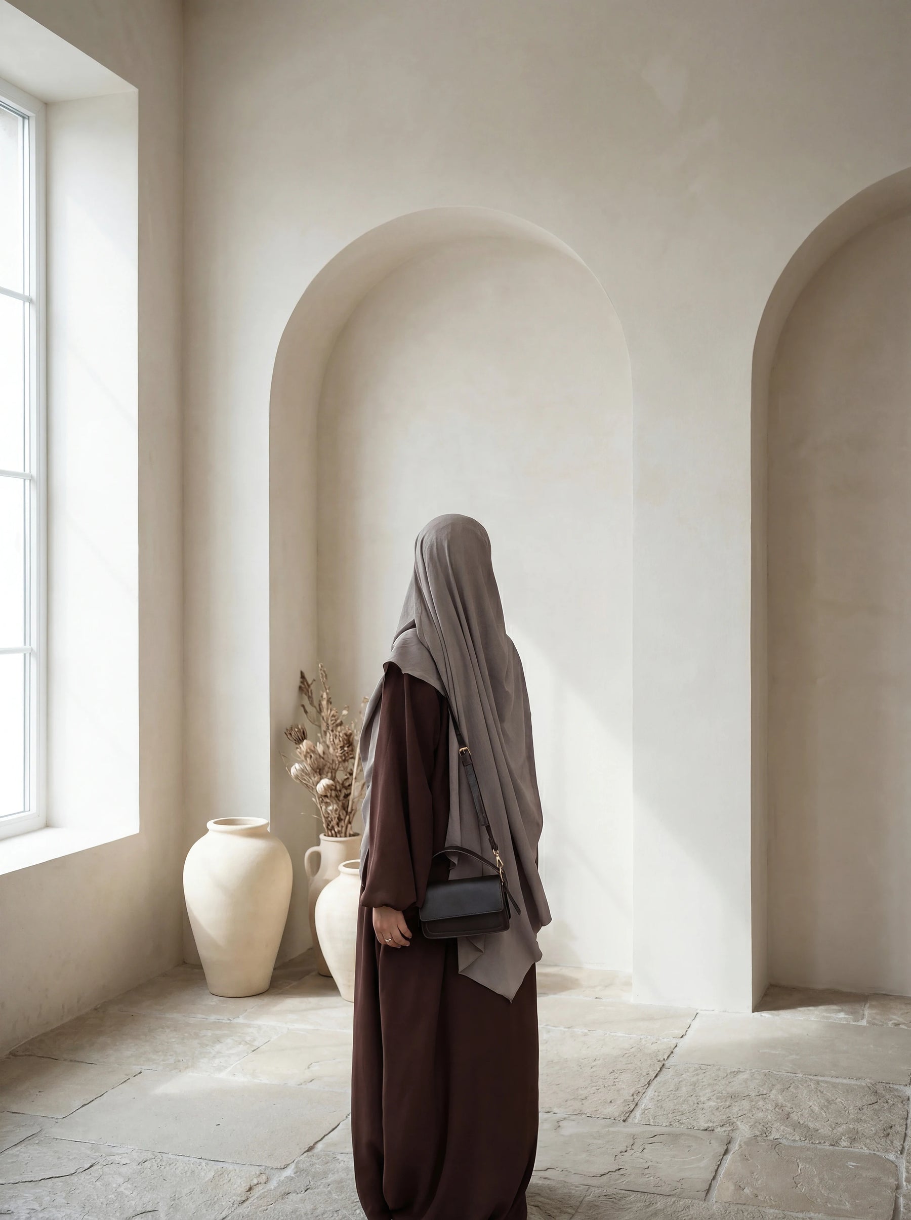 Eine braune Still-Abaya aus leichtem Jazzstoff mit Ballonärmeln ist in Frontansicht zu sehen.