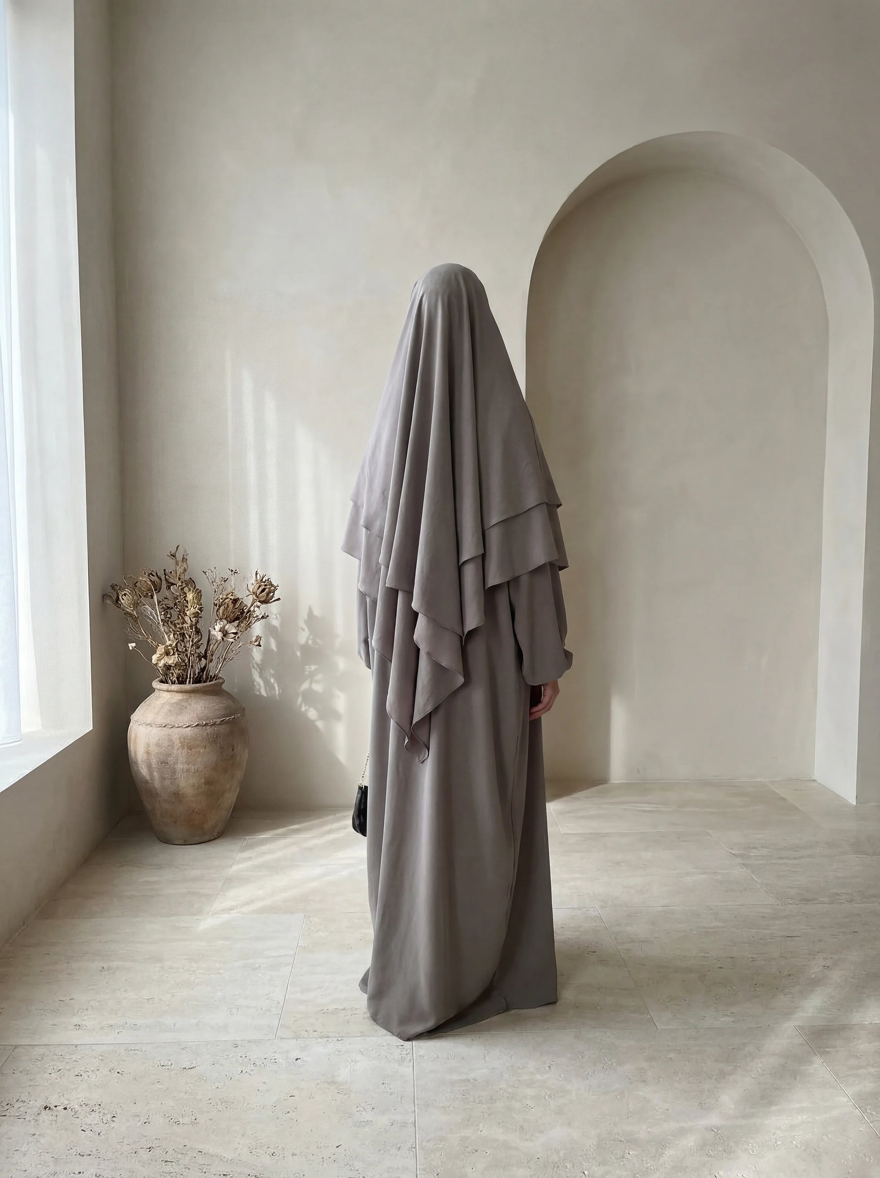 Schwarze Abaya aus fließendem Viskose-Mix mit zweilagigem Khimar und Ballonärmeln, Vorderansicht.