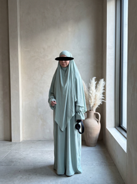 salbeigrünes abaya‑khimar set aus fließendem stoff, abaya mit ballonärmeln, khimar mit doppellagigem saum, frontansicht