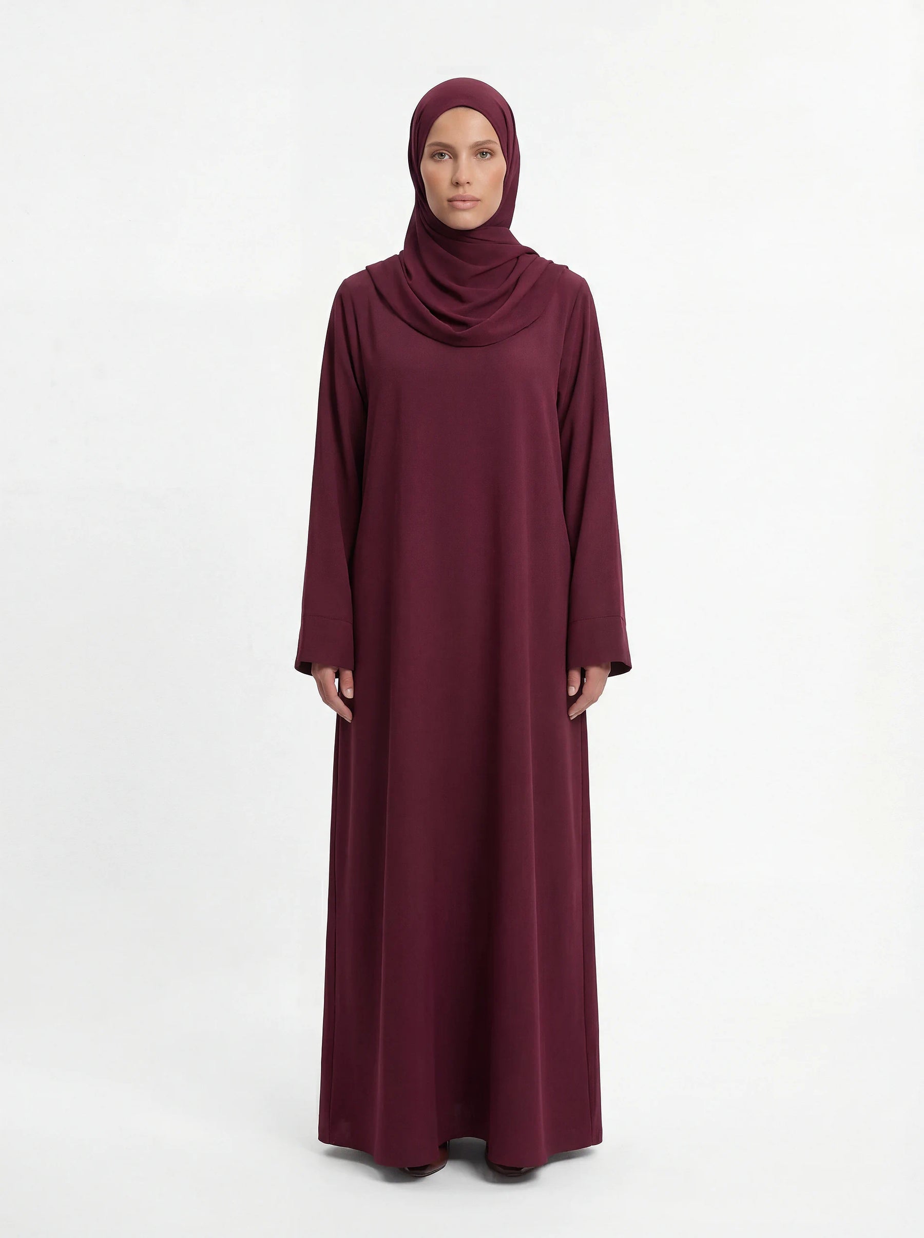 bordeauxrote lange abaya aus polyester mit weiten ärmeln und rundhalsausschnitt, vorderansicht auf schaufensterpuppe