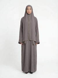 Taupefarbene Einteiler-Abaya aus Crêpe mit integriertem Hijab und goldener Kantenpaspel, Vorderansicht