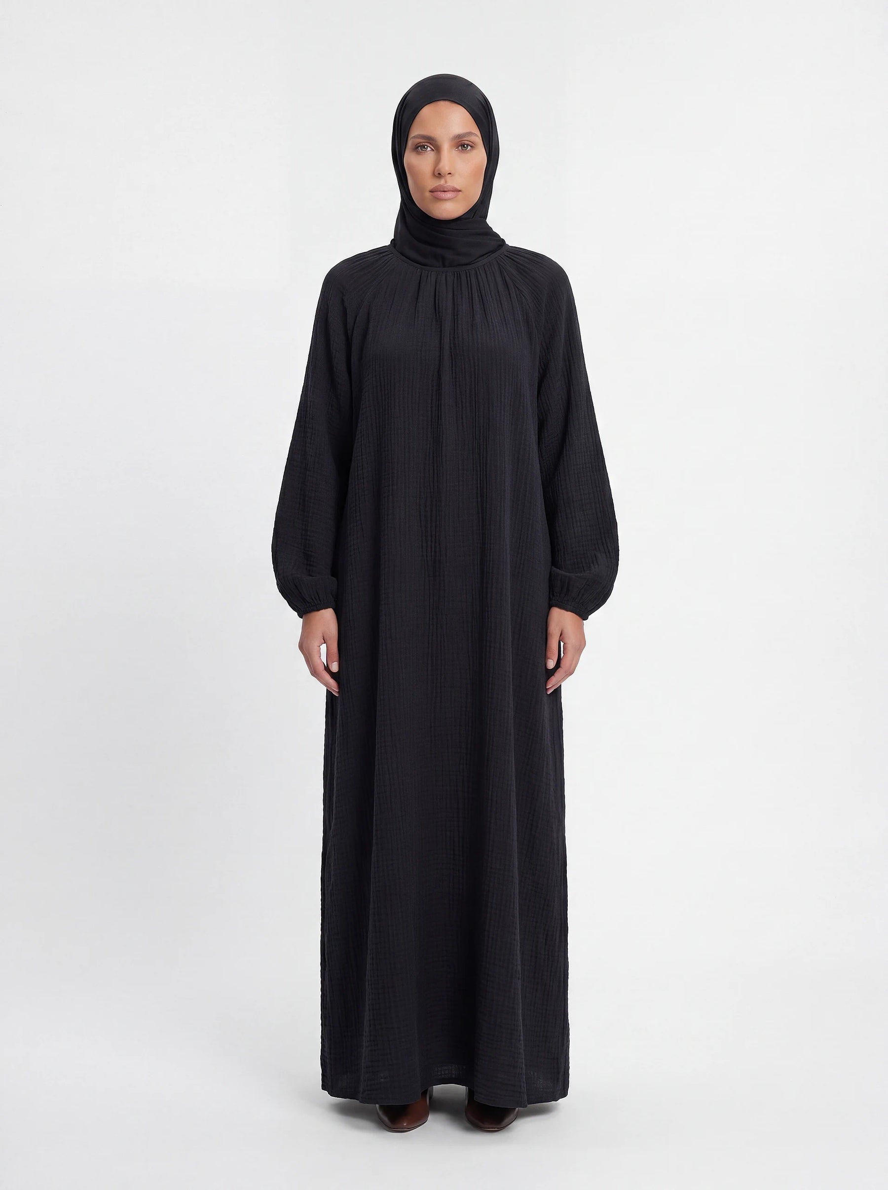 Schwarzes Maxi-Kleid aus strukturiertem Stoff mit Raffungen am Halsausschnitt und weiten Ärmeln, Frontalansicht.