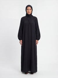 Schwarzes Maxi-Kleid aus strukturiertem Stoff mit Raffungen am Halsausschnitt und weiten Ärmeln, Frontalansicht.
