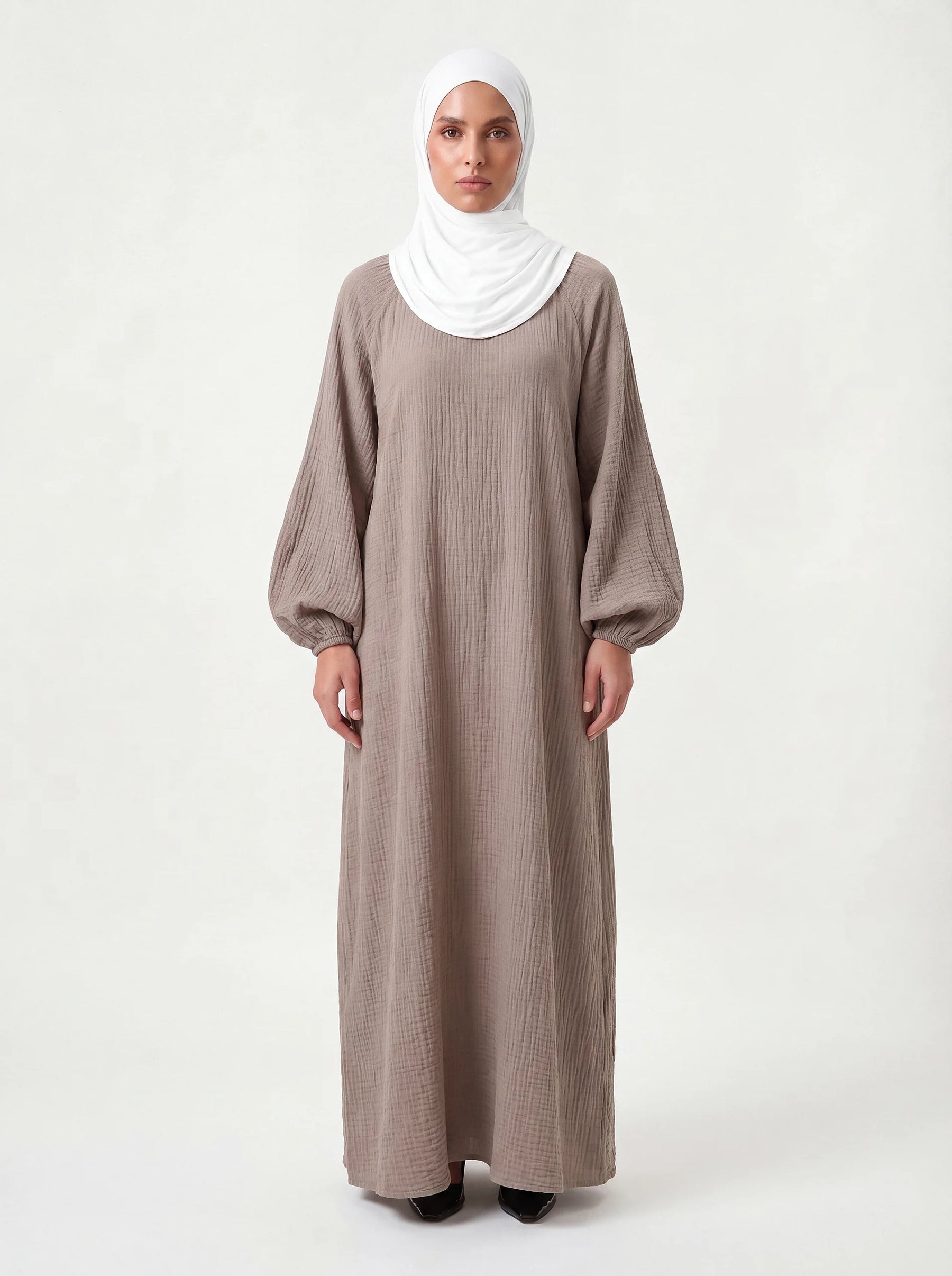 Bodenlanges Kleid in taupe aus strukturiertem Stoff mit weiten Ballonärmeln und Rundhalsausschnitt, Frontalansicht.