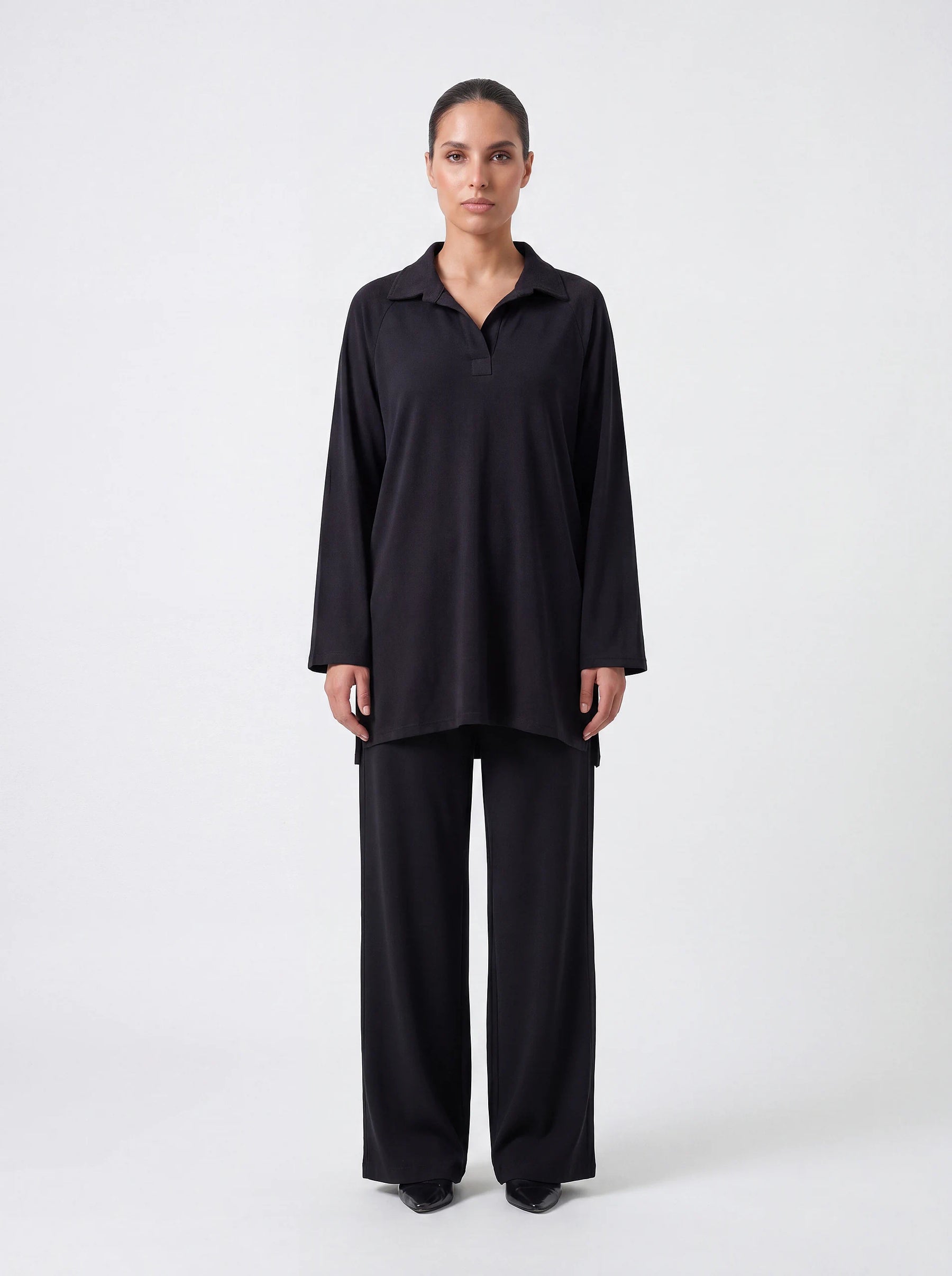 Schwarzer Kragenpullover mit V-Ausschnitt und Seitenschlitzen, Frontalansicht der lockeren Passform.