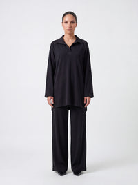 Schwarzer Kragenpullover mit V-Ausschnitt und Seitenschlitzen, Frontalansicht der lockeren Passform.