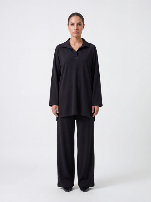 Schwarzer Kragenpullover mit V-Ausschnitt und Seitenschlitzen, Frontalansicht der lockeren Passform.