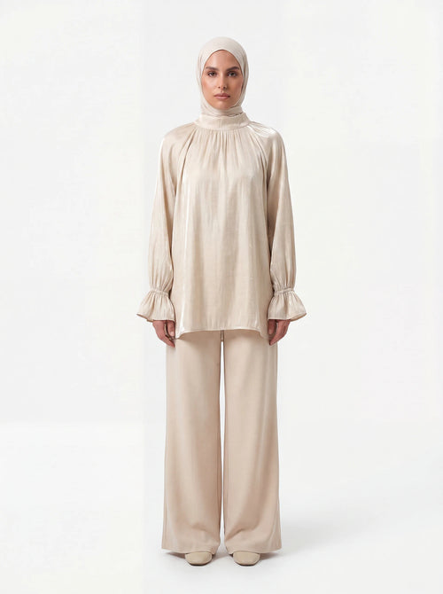 Champagnerfarbene Bluse aus glänzendem Stoff mit gerafftem Kragen und Volant-Ärmeln, Frontalansicht.