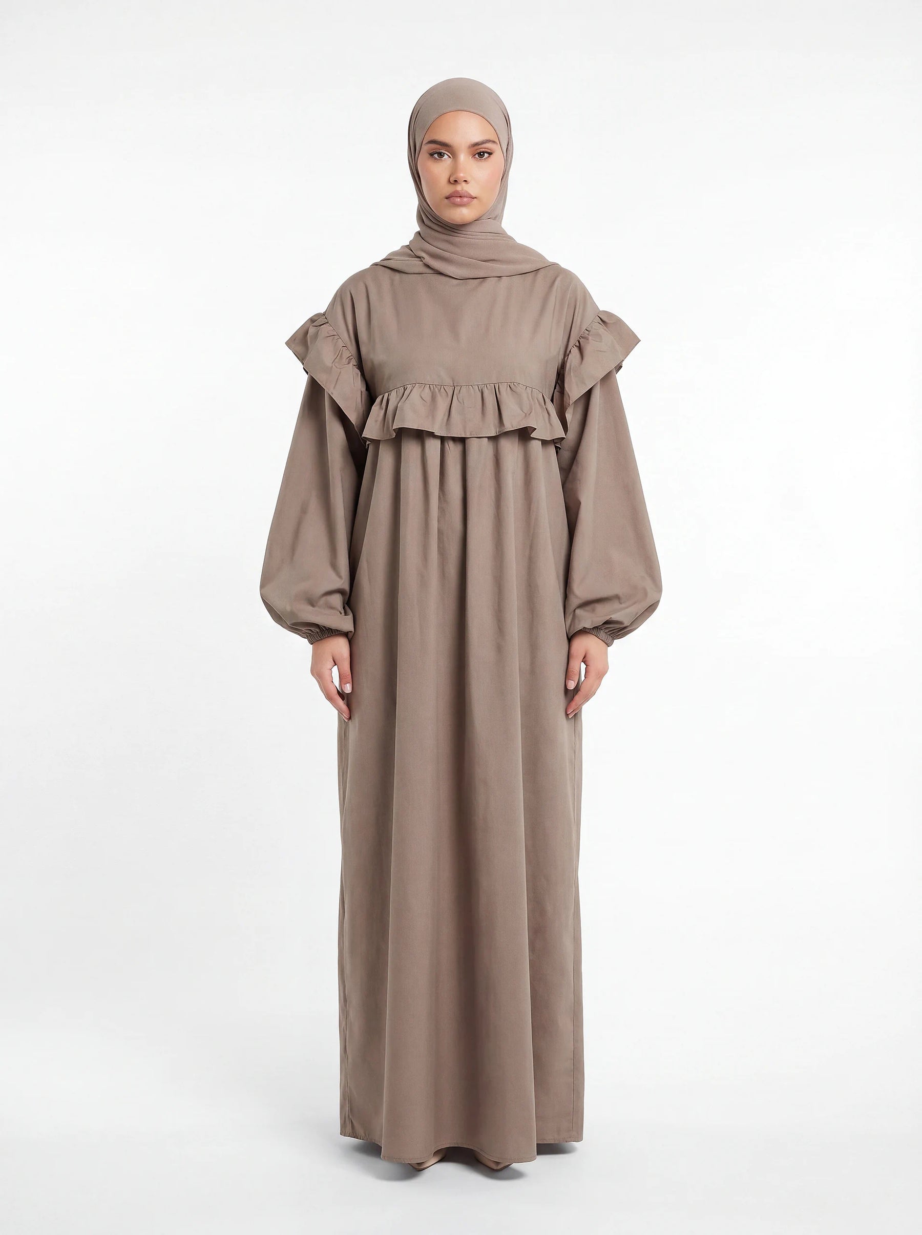 Bodenlanges Kleid in Taupe mit breiter Rüsche über Brust und Schultern sowie weiten Ballonärmeln.