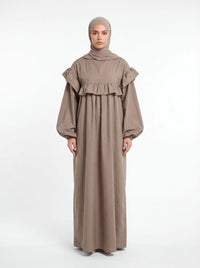 Bodenlanges Kleid in Taupe mit breiter Rüsche über Brust und Schultern sowie weiten Ballonärmeln.
