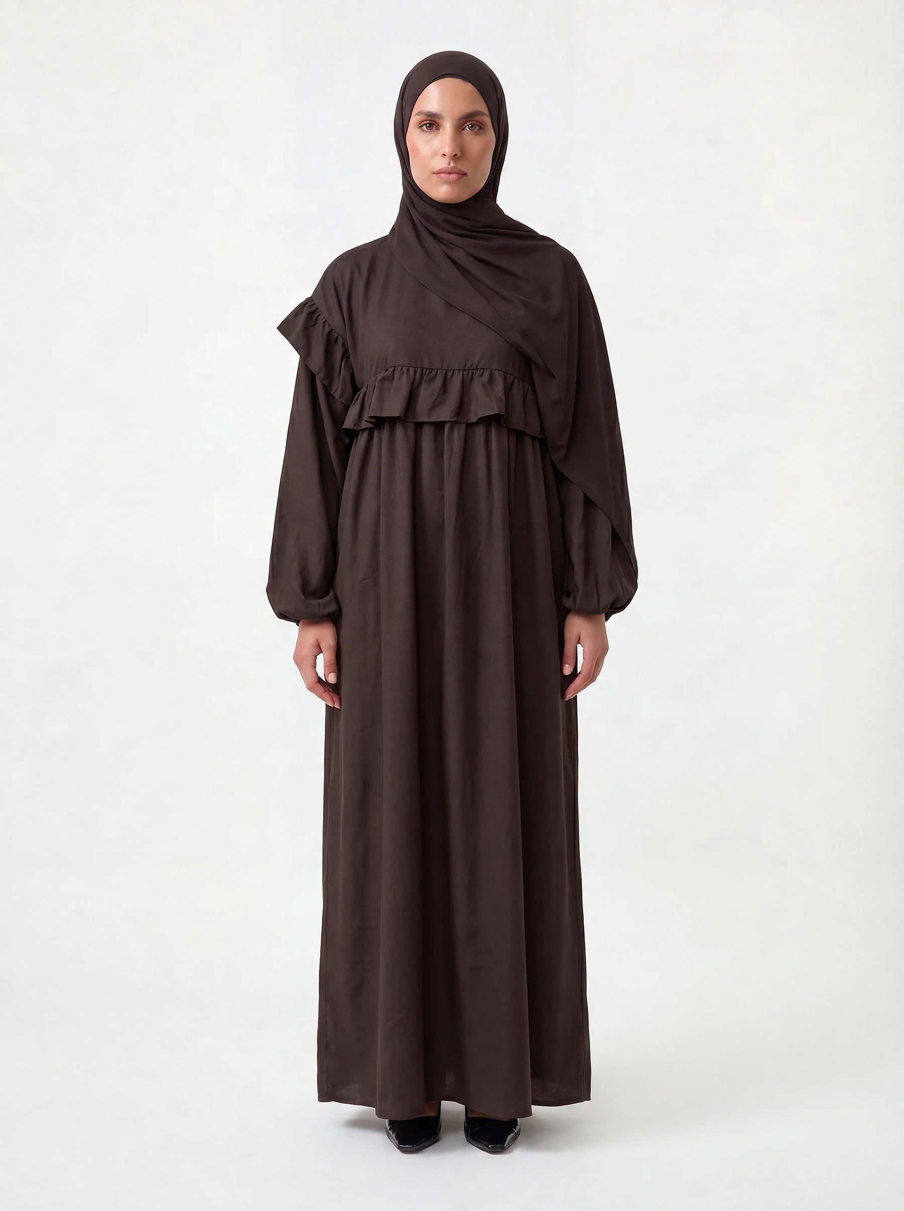 Schokobraunes Kleid mit waagerechter Rüsche über der Brust, Ballonärmeln und passendem Hijab, Frontalansicht.