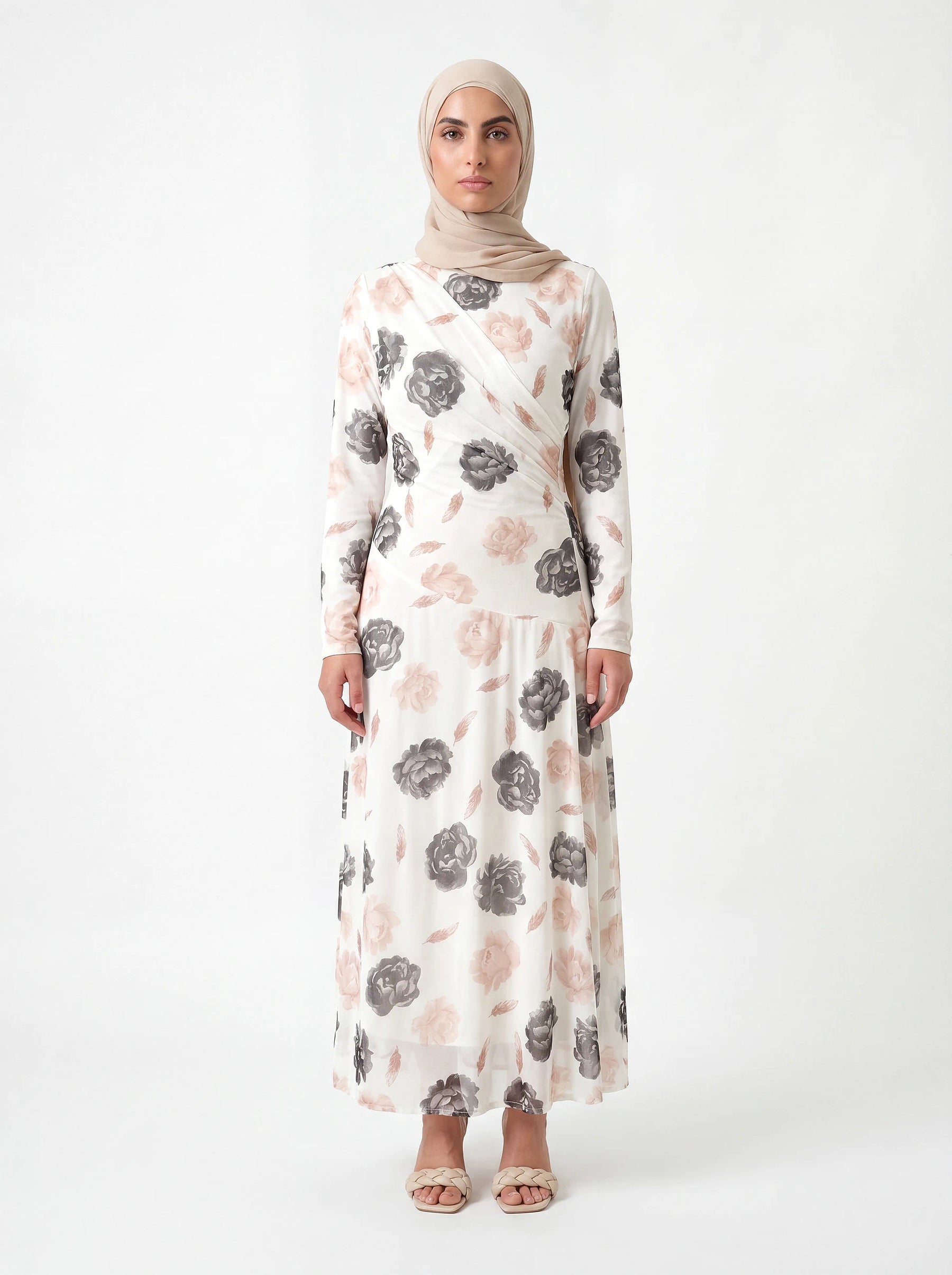 Weißes Kleid mit großem Blumenmuster in Grau und Altrosa, langärmelig mit Wickeloptik am Oberkörper, Frontalansicht.
