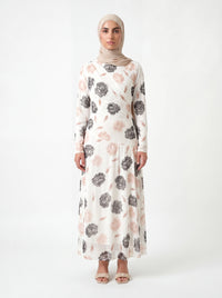 Weißes Kleid mit großem Blumenmuster in Grau und Altrosa, langärmelig mit Wickeloptik am Oberkörper, Frontalansicht.