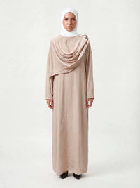 Bodenlanges Cape-Kleid in Sandbeige mit drapiertem Brustdetail und langen Ärmeln, Frontalansicht.