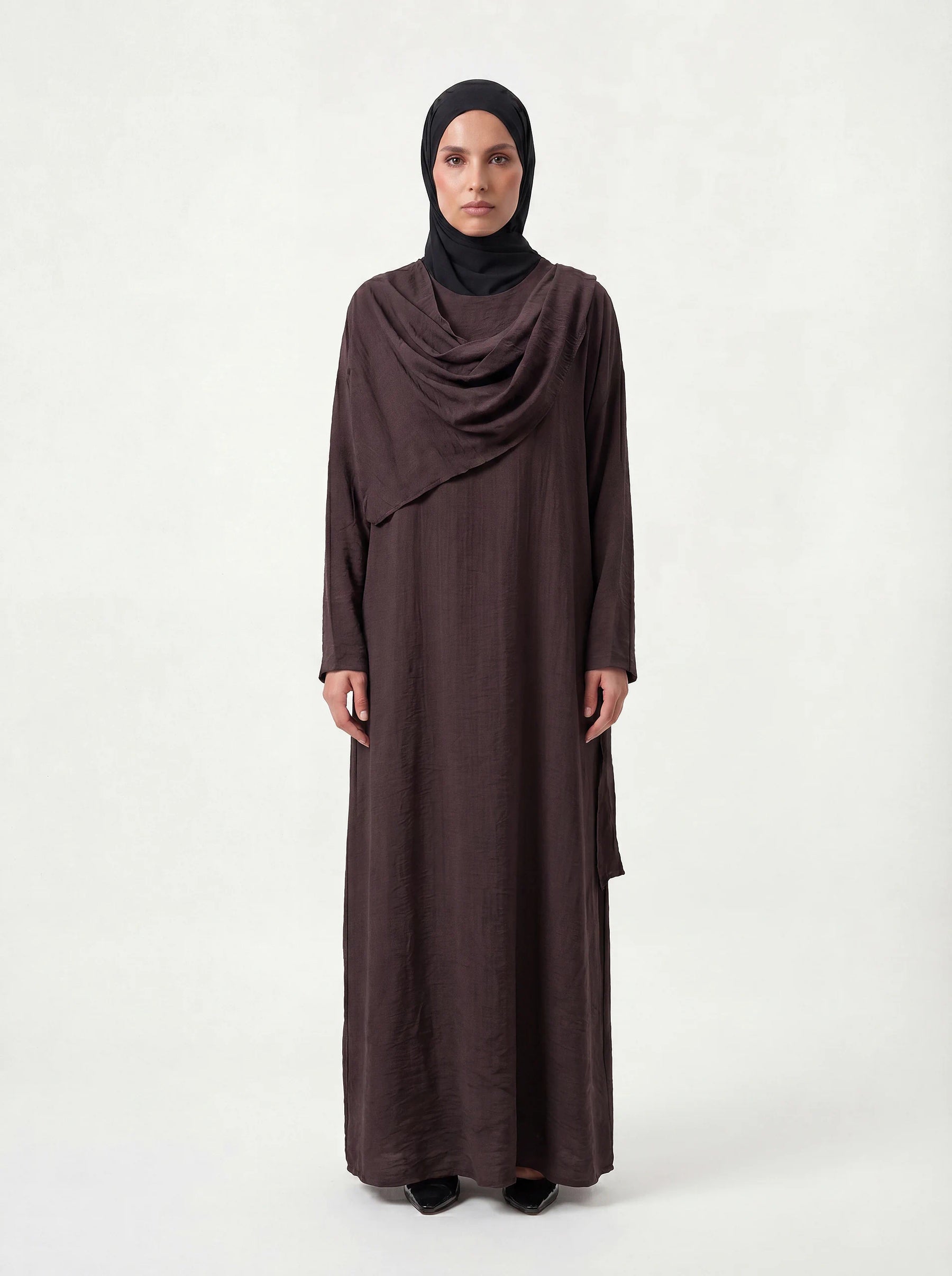 Schokobraunes, langes Cape-Kleid mit integriertem Brust-Überwurf und schmalen Ärmeln, Frontalansicht.