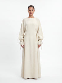Cremeweiße Abaya mit Schleifendetails an der Taille und den Ärmelabschlüssen, Frontalansicht.