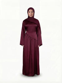 Bordeauxrotes Abendkleid aus glänzendem Stoff mit weiten Ärmeln, diagonaler Taillennaht und passendem Hijab.