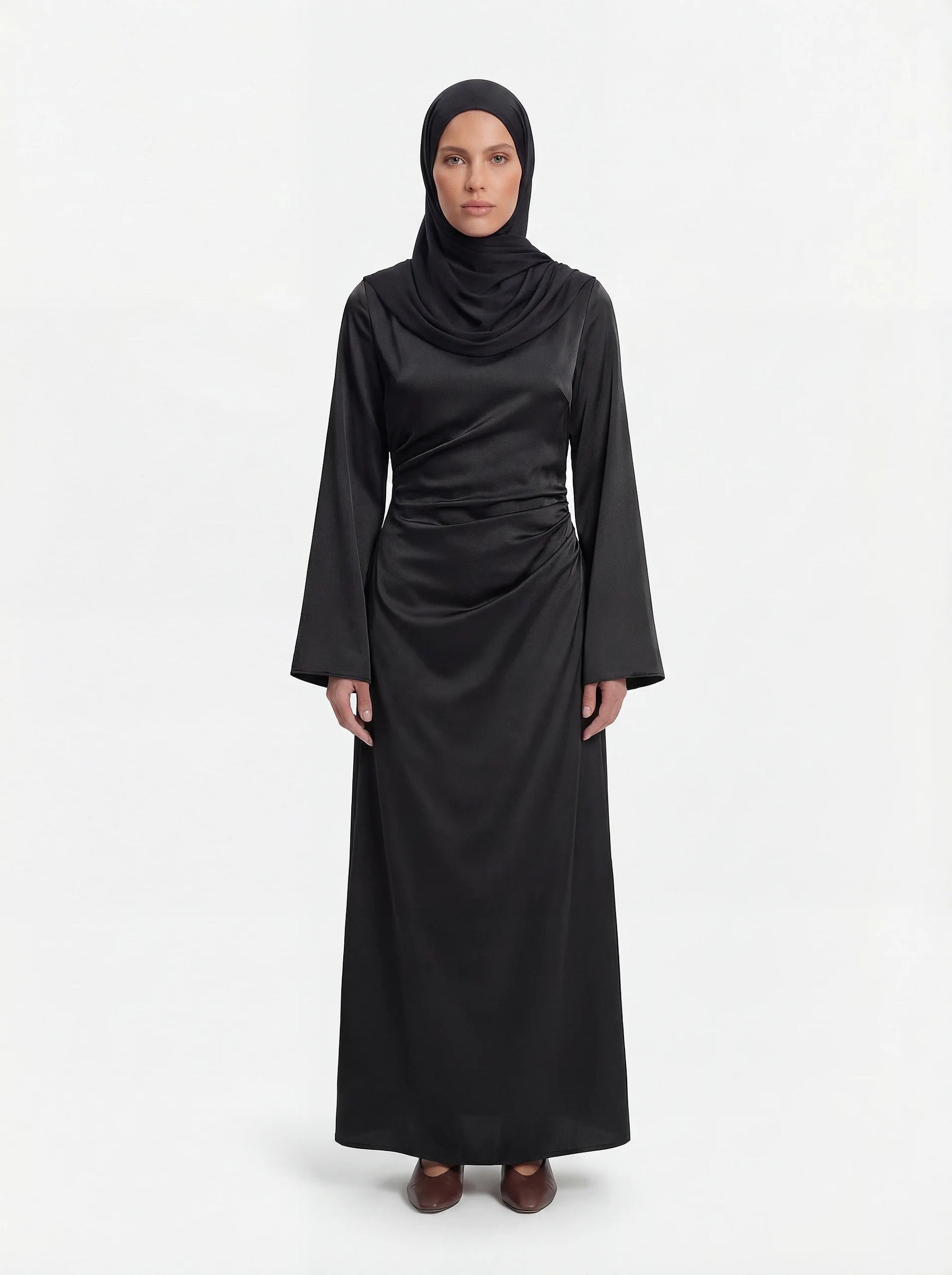 Schwarzes Mira Kleid aus glänzendem Stoff mit Taillenraffung und langen Ärmeln, Frontalansicht.