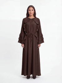 Maxikleid in dunkelbraun mit Rüschenbesatz vorne, gestuften Ärmelrüschen und Bindegürtel, Frontalansicht.