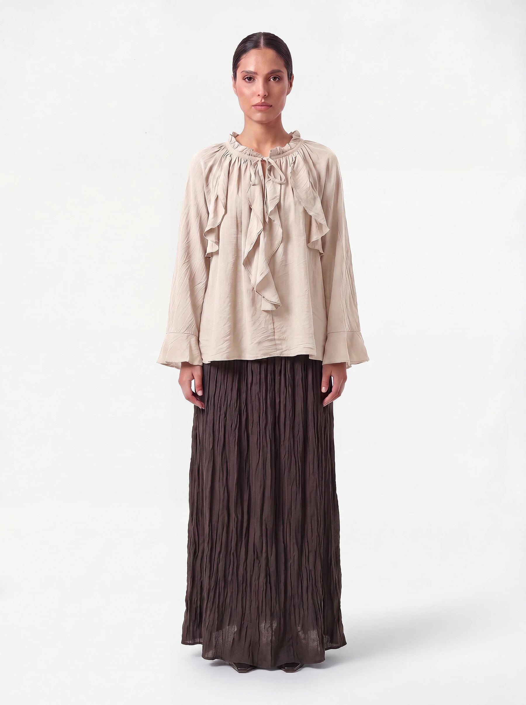 Sandfarbene Bluse mit Rüschenkragen, Bindeband und weiten Ärmelabschlüssen, Frontalansicht.