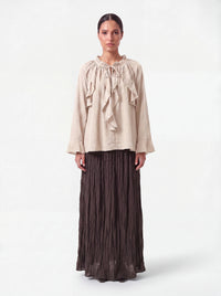 Sandfarbene Bluse mit Rüschenkragen, Bindeband und weiten Ärmelabschlüssen, Frontalansicht.