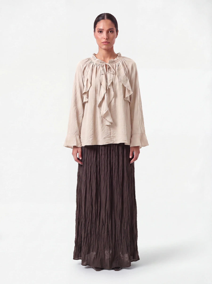 Sandfarbene Bluse mit Rüschenkragen, Bindeband und weiten Ärmelabschlüssen, Frontalansicht.