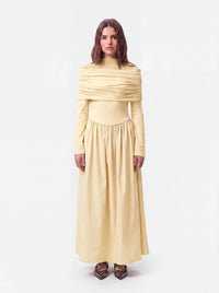 Vanillegelbes Kleid mit drapiertem Schulterdetail, langen Ärmeln und gerafftem Rockteil, Frontalansicht.