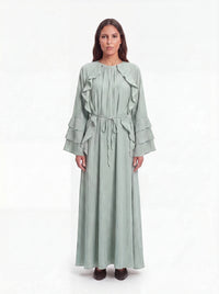 Salbeigrünes Maxikleid mit Rüschenbesatz vorne, gestuften Ärmelrüschen und Bindegürtel, Frontalansicht.