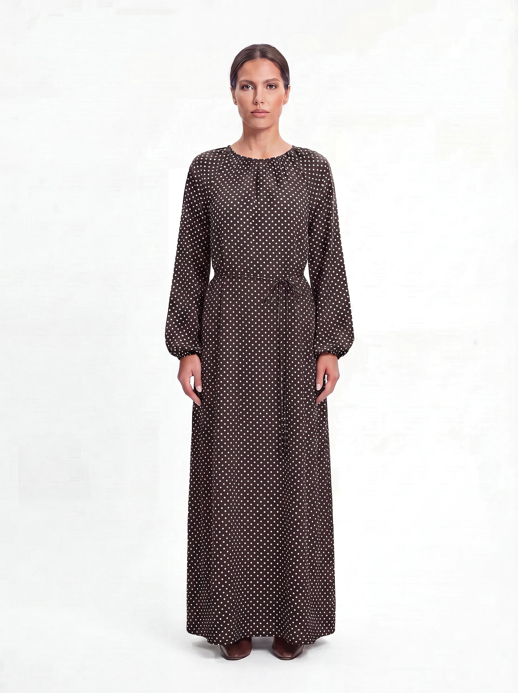 Maxikleid in dunkelbraun mit weißem Punktemuster, Ballonärmeln und Bindegürtel, Frontalansicht.